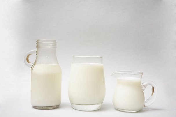 Milk bottle,  jug and glass of milk isolated on  paper  background. - Foto, Bild
