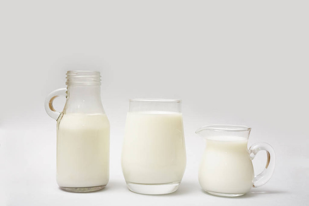 Milk bottle, jug and glass of milk isolated on  paper background - Foto, afbeelding