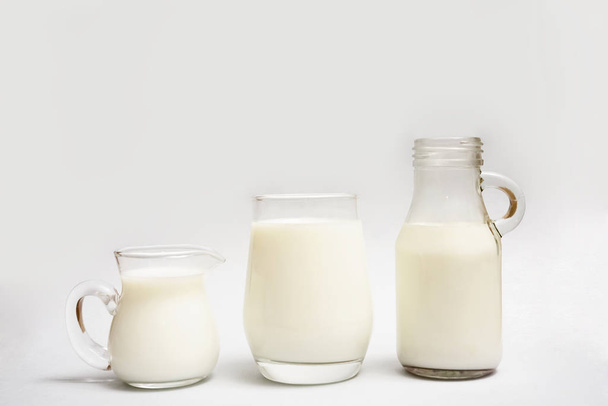 Milk bottle,  jug and glass of milk isolated on  paper  background. - Zdjęcie, obraz