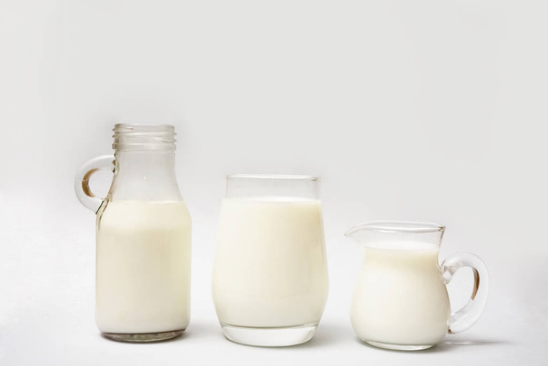 Milk bottle,  jug and glass of milk isolated on  paper  background. - Фото, изображение