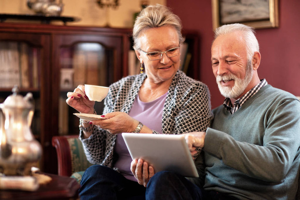 Senior couple having fun with the internet while enjoying their time - Foto, afbeelding