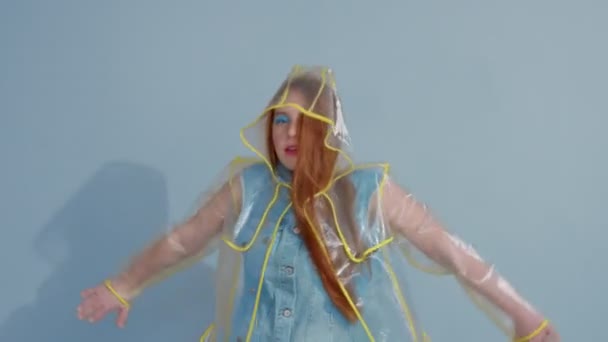 ginger hair woman in transparent raincoat with pop art bright makeup dancing - Кадри, відео