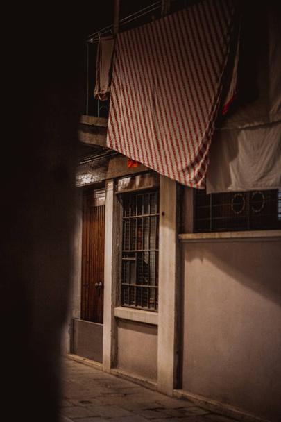 pohled z úzké uličce s suché oblečení na laně ve staré čtvrti v noci, Benátky, Itálie  - Fotografie, Obrázek