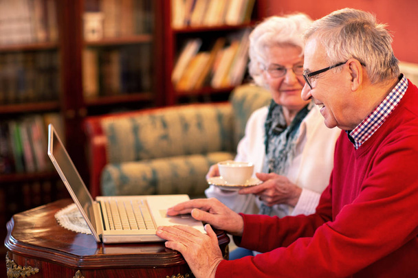 Старша пара читає новини з Інтернету і весело вивчає Інтернет
 - Фото, зображення