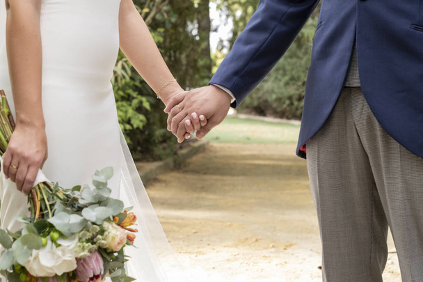 couple amoureux serrant la main, elle avec bouquet de fleurs
 - Photo, image