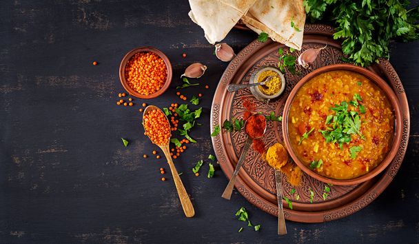 Indian dal. Food. Traditional Indian soup lentils.  Indian Dhal spicy curry in bowl, spices, herbs, rustic black wooden background. Top view. Authentic Indian dish. Overhead. Flat lay - Photo, Image