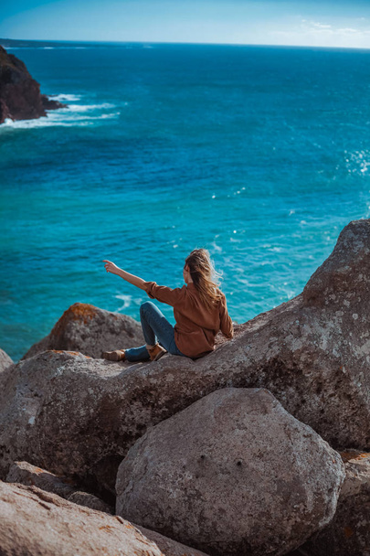woman relaxing on rocky cliff Cabo da Roca, Portugal  - Fotografie, Obrázek