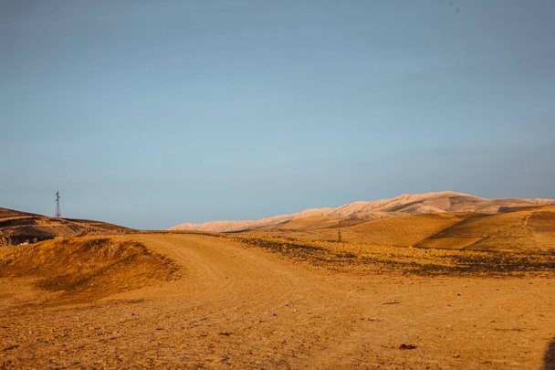 dirty road among sandy hills under blue sky  - Fotografie, Obrázek
