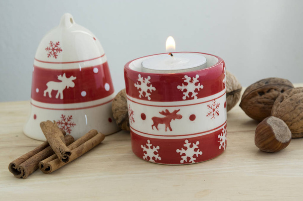 Christmas candlestick and bell, red and white color, wooden tray, red Christmas ornaments - Φωτογραφία, εικόνα