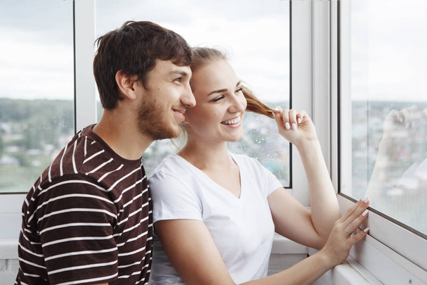 Paar schaut aus dem Fenster im neuen Zuhause - Foto, Bild