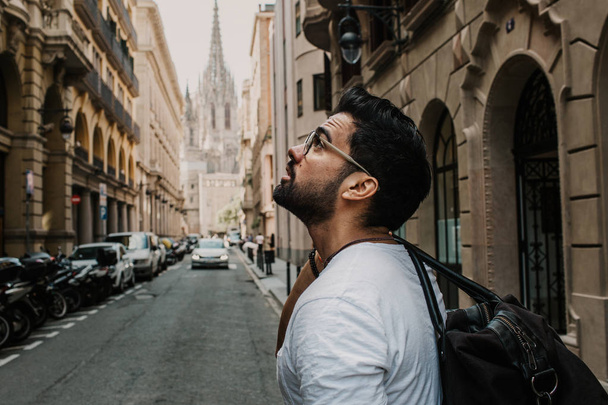 Traveler male discover a big europe city, travel and active lifestyle concept.Bearded Tourist Man with black leather bag enjoy beautiful city travel. Cropped. - Foto, Bild