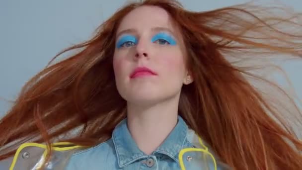 mujer de pelo jengibre en impermeable transparente con el arte pop brillante maquillaje baile
 - Metraje, vídeo
