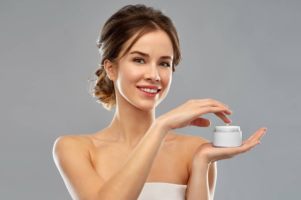 happy young woman holding jar of cream - Foto, imagen