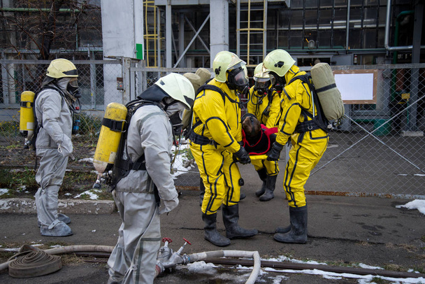 Firefighters and rescuers in a radiation protection, chemical protection suit  rescue the injured. - Photo, Image