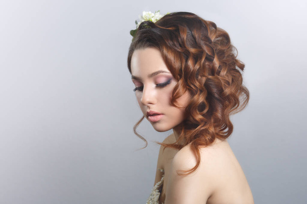 Portrait of young woman with flowers in hairstyle  - Photo, Image