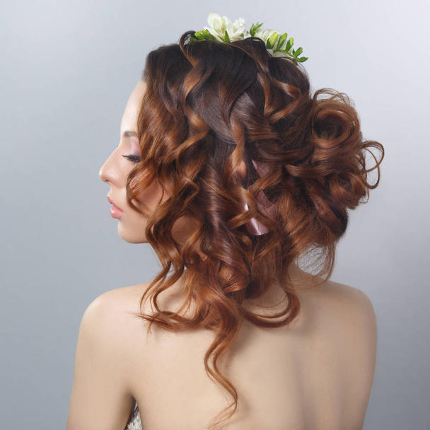 Portrait of beautiful young woman with flowers in hairstyle  - Foto, imagen