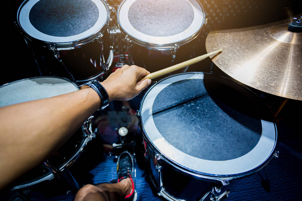 homem tocando o conjunto tambor com tambores de madeira na sala de música, o conceito de instrumento musical
 - Foto, Imagem