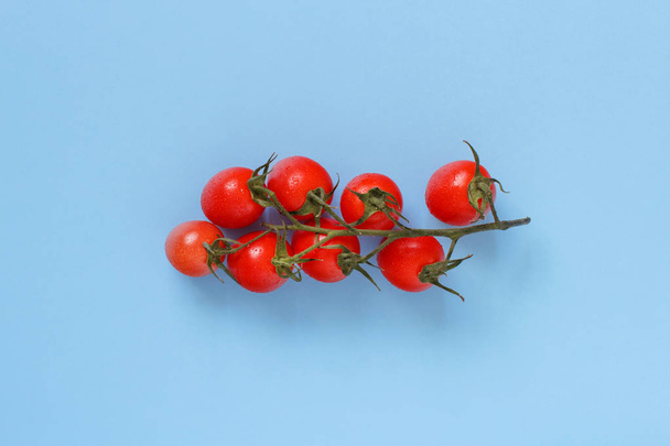 Cherry tomatoes on a blue background close up - Valokuva, kuva