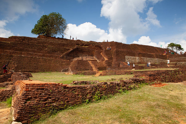 Sigiriya, Sri Lanka - January 22,2019: Ruins on top of Sigiriya Lion's rock palace The name refers to a site of historical and archaeological significance that is dominated by a massive column of rock - Photo, image