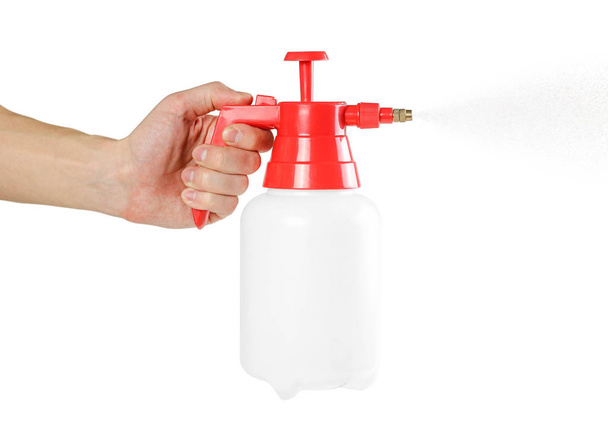 Hand holding red garden sprayer. Close up. Isolated on white background. - Photo, Image