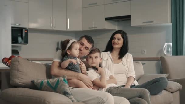 Familia feliz viendo la televisión en casa en el sofá
 - Metraje, vídeo