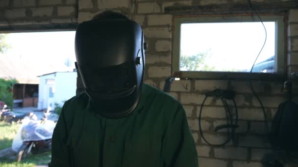 Mechanic doing his work using protective mask. Man in workwear worksin garage or workshop. Guy wears protective mask for his safety. Hard work concept. Slow motion Close up. - Footage, Video