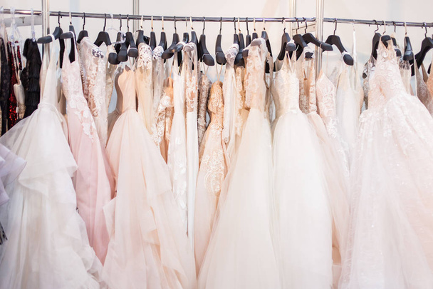 Stand mit vielen schönen Brautkleidern im Showroom. - Foto, Bild