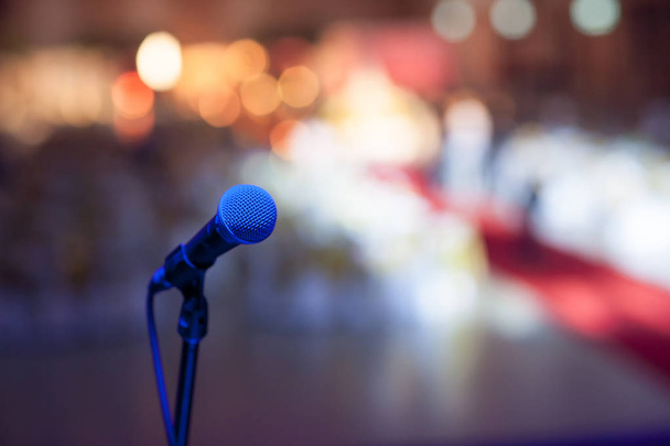 mikrofon koncertteremben vagy konferenciateremben lágy és elmosódott stílus a háttérben.Mikrofon az elvont elmosódott fénykép konferenciaterem vagy szemináriumterem háttér. - Fotó, kép