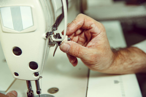 Sewing process of the leather belt. old Mans hands behind sewing. - Photo, Image