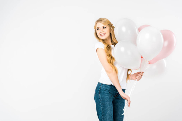 beautiful woman in white t-shirt and blue jeans holding air balloons on white background - Foto, Imagen