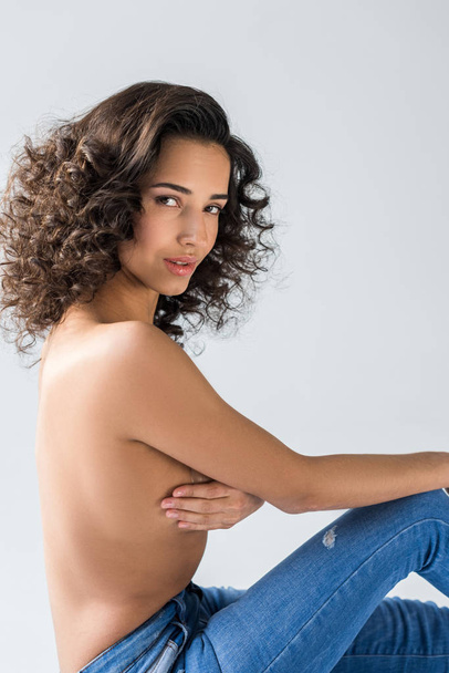 Charming topless girl in jeans looking at camera on grey background - Zdjęcie, obraz