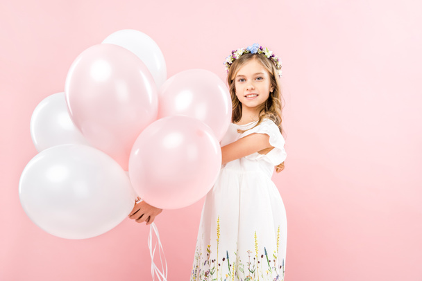 adorable smiling child holding festive air balloons on pink background - Photo, image