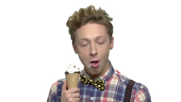 Dospívající chlapec jíst zmrzlinu na bílém pozadí. - Záběry, video
