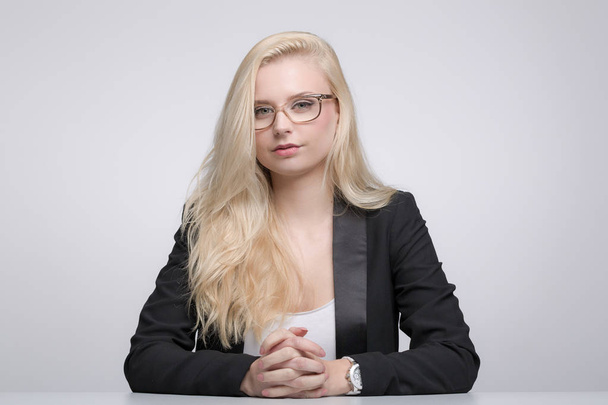 young pretty woman with long blonde hair and glasses is sitting at desk - Photo, image