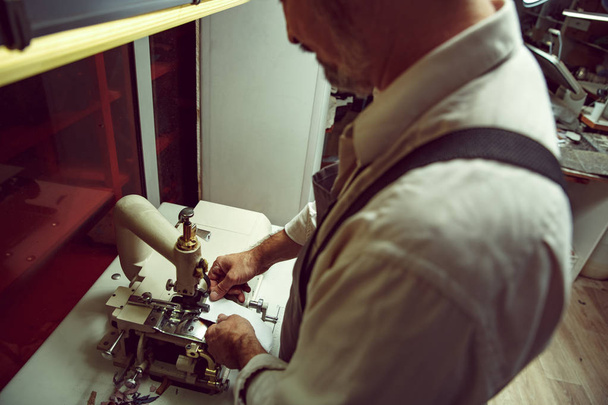 Sewing process of the leather belt. old Mans hands behind sewing. - Photo, Image