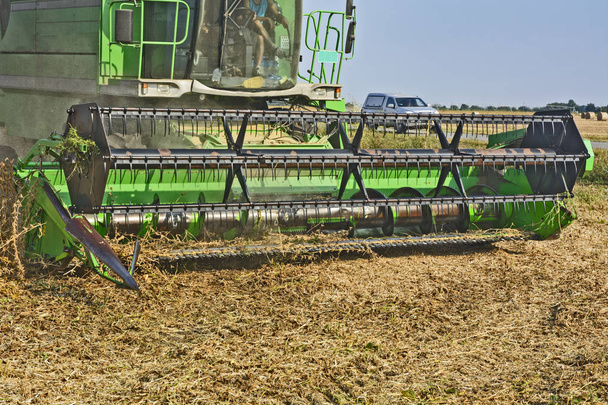 Erntemaschine bei der Arbeit auf dem Feld der Sojabohnen an einem schönen und sonnigen Tag. - Foto, Bild