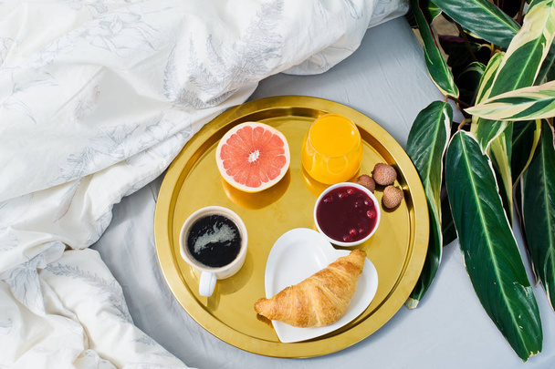 クラシック ベッドで朝食、ホテル サービス。コーヒー、ジャム、クロワッサン、オレンジ ジュース、グレープ フルーツ、ライチ。上面ビュー、明るい背景 - 写真・画像