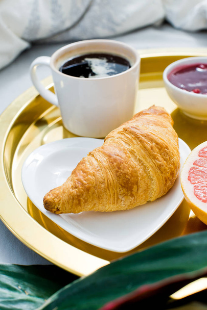 Classic Breakfast in bed, hotel service. Coffee, jam, croissant, orange juice, grapefruit, lychee. Top view, light background - Fotografie, Obrázek