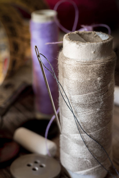 ferramentas de costura variuous com, agulha e linha, algodão, botões na madeira velha
 - Foto, Imagem