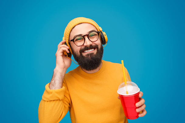 Man with drink listening to music - Foto, Bild