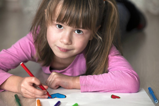 Dítě dívka kreslení s barevné tužky pastelky srdce na bílém papíře. Výtvarná výchova, kreativní koncepce. - Fotografie, Obrázek