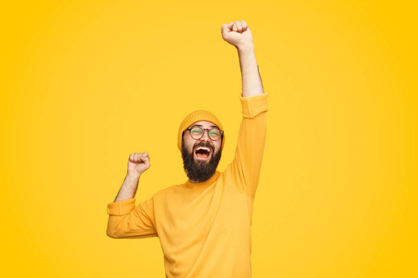 Excited bright man with fist up - Foto, Bild