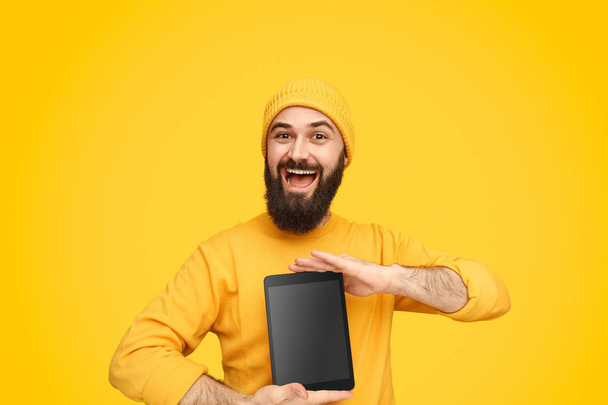 Cheerful man demonstrating tablet - Foto, Imagen