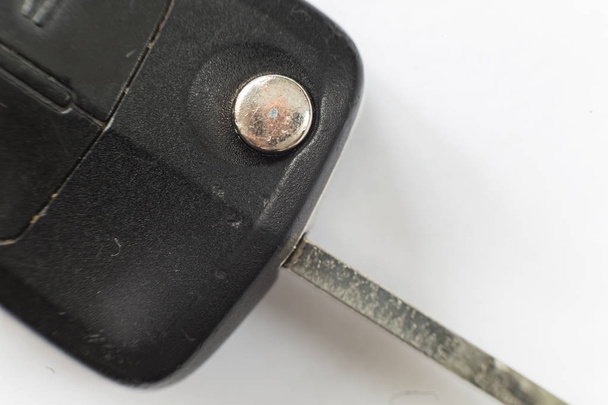 Close-up van auto sleutel met de knoppen van de afstandsbediening op witte achtergrond. Voertuig slot en sleutels design, veiligheid en transport concept. - Foto, afbeelding