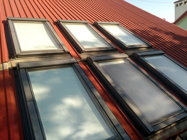 Červená vedle sebe dům střecha se střešní okna. Střešní konstrukce, montáž oken, moderní architektura koncept. - Fotografie, Obrázek