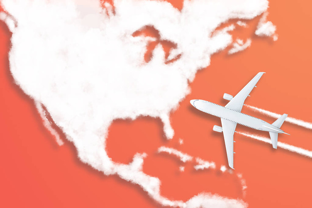 Model vliegtuig ontwerp miniatuur rode achtergrond pluizige wolken in de vorm van het continent Noord-Amerika. Het idee van tickets voor de reis, reizen per vliegtuig, nieuwe ontdekkingen, zomervakantie. - Foto, afbeelding