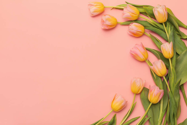 Hermosas flores en el fondo de papel de color. Tulipanes rosados y papel
 - Foto, imagen