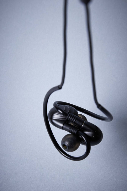 headphones for music entwined, close-up on a light isolated background - Photo, Image