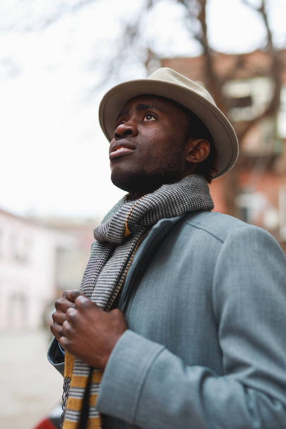 Street portrait of african american man in coat and hat at city - Foto, Imagem