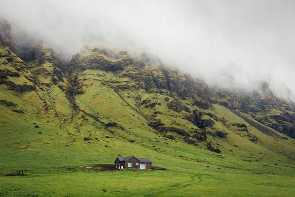 Pequena casa de campo moderna de madeira vista da chamada Ring Road no sul da Islândia
 - Foto, Imagem